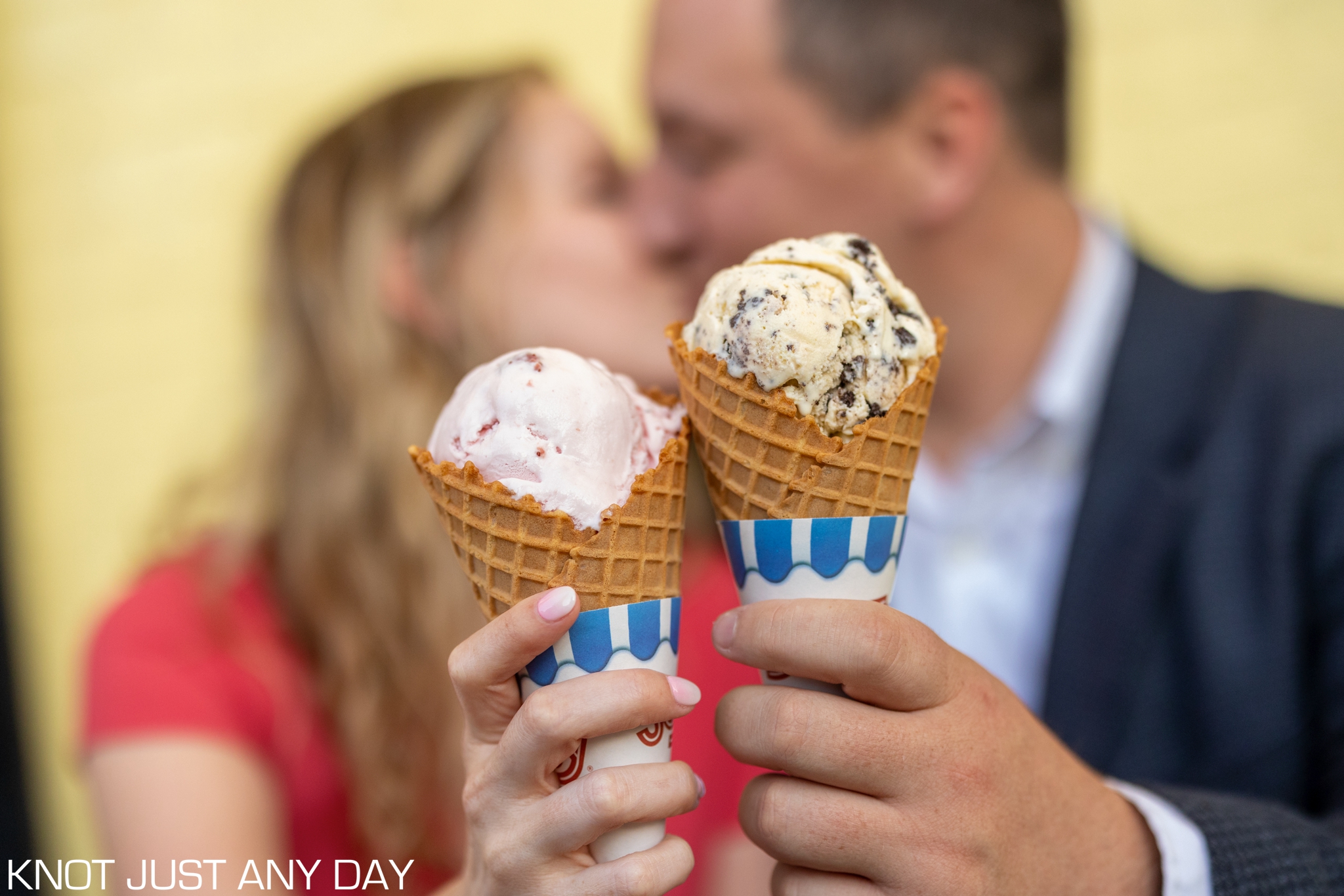engagement photo of couple kissing and holding ice cream cones outside of Congress Hall in Cape May, NJ