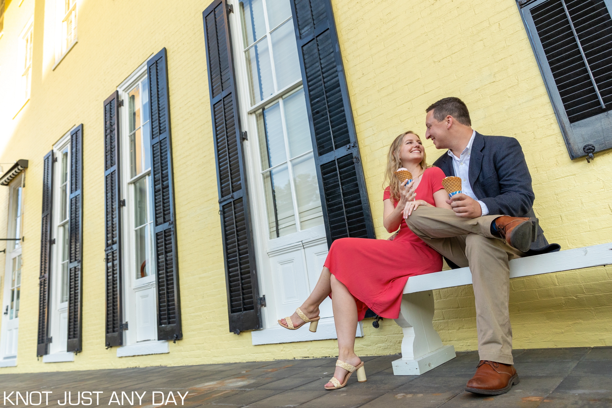 engagement photo of couple sitting and holding ice cream cones outside of Congress Hall in Cape May, NJ