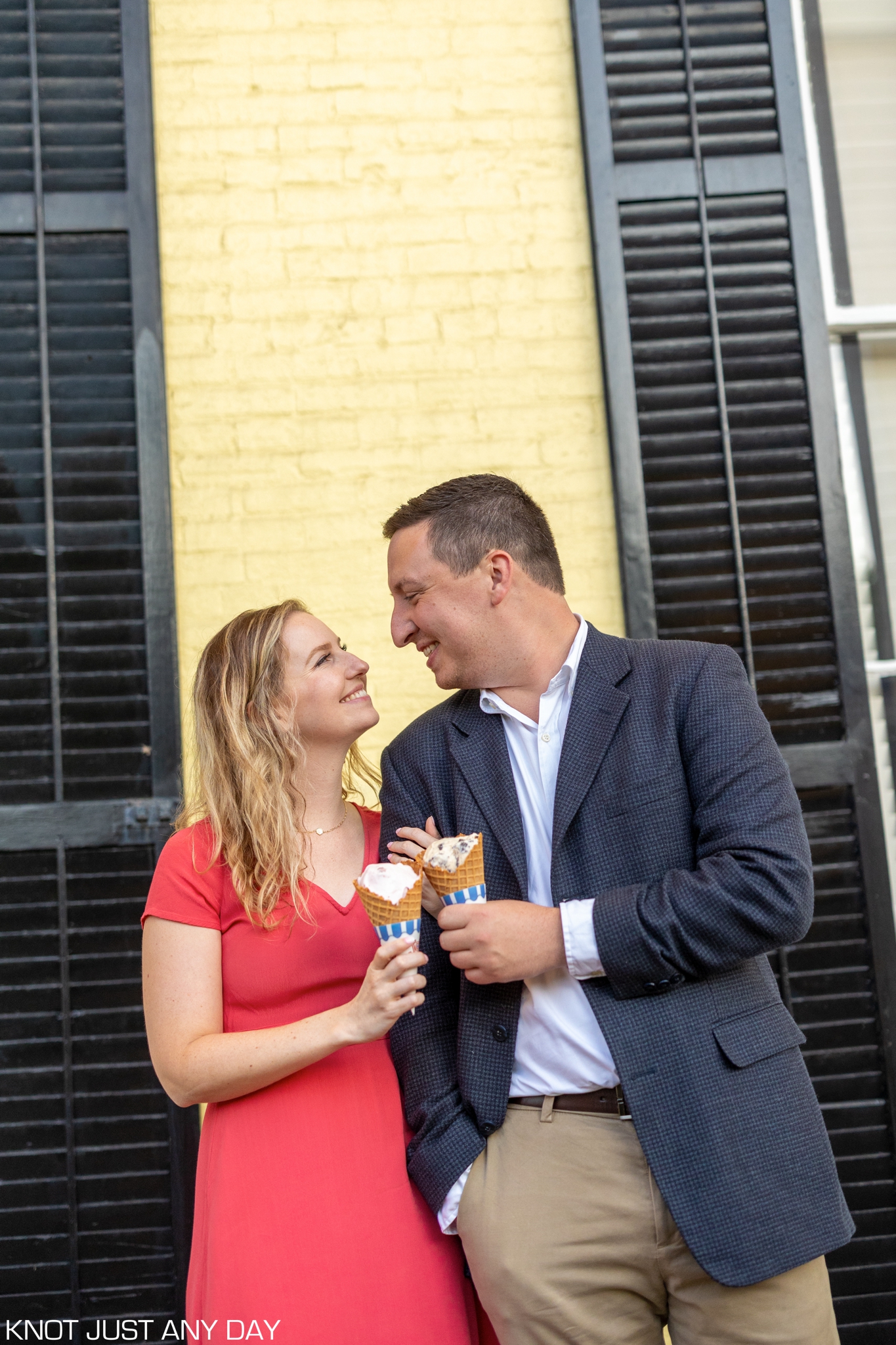 engagement photo of couple standing and holding ice cream cones outside of Congress Hall in Cape May, NJ