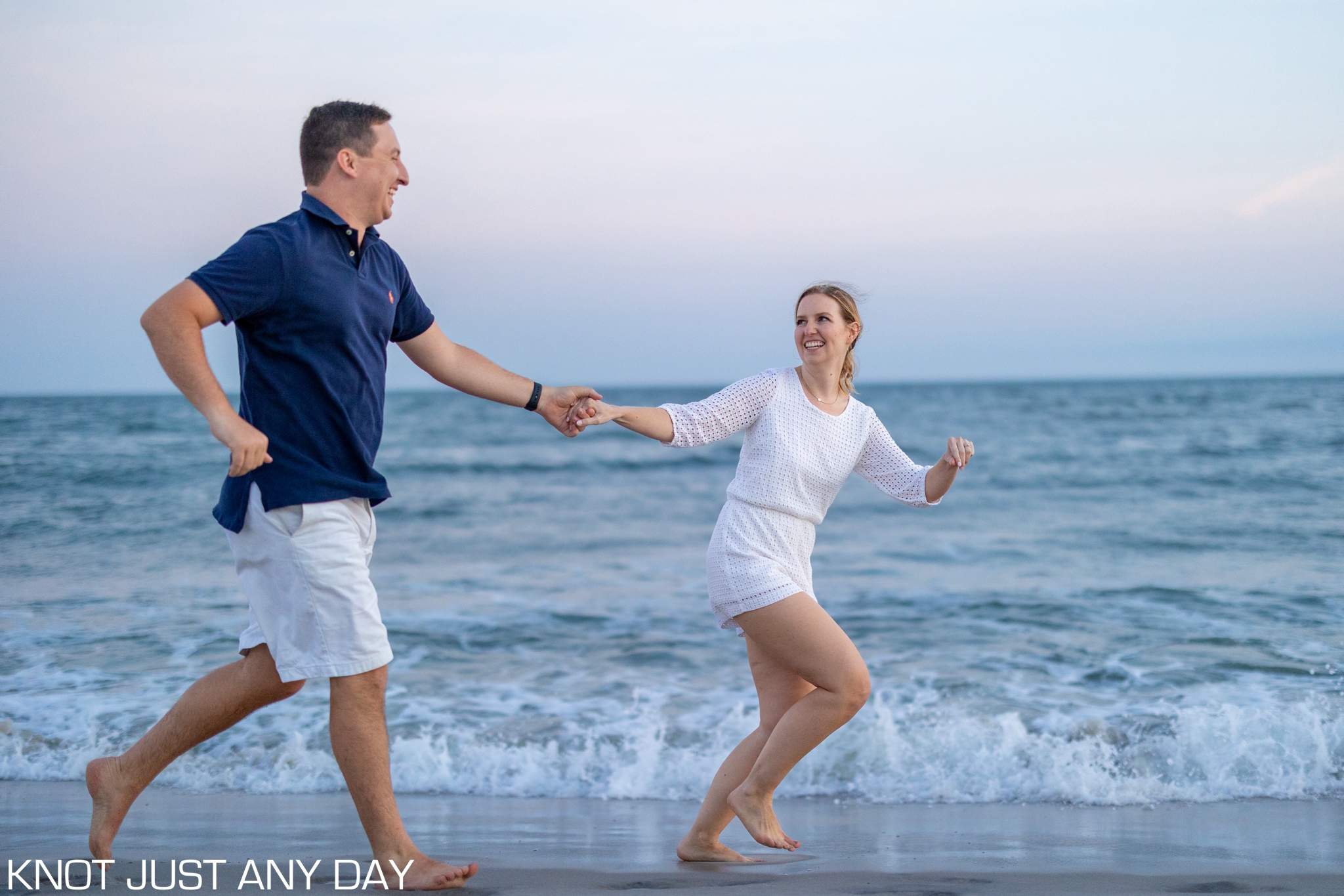 engaged couple running on the beach during sunset in Cape May, NJ