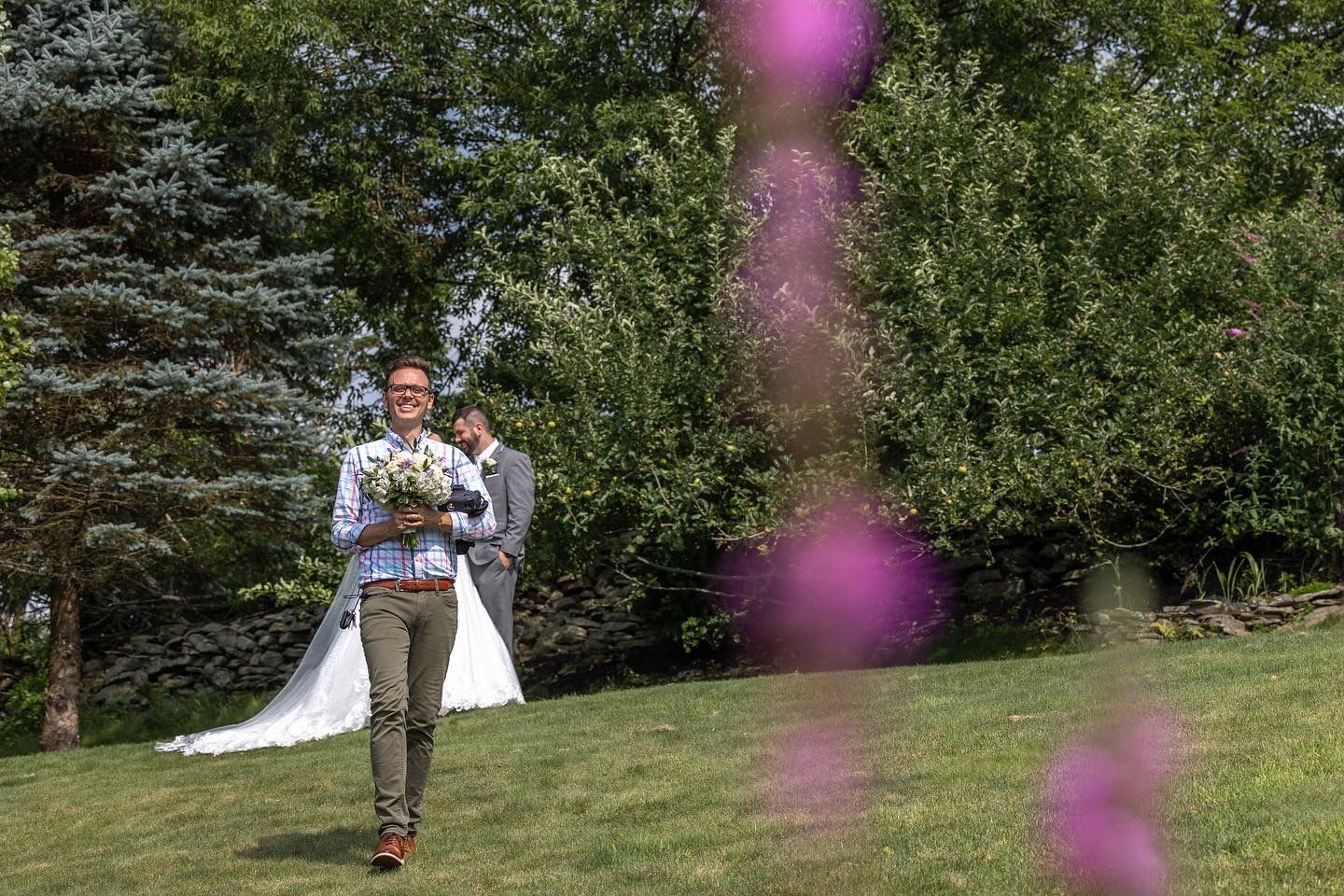 wedding photographer holding bride's bouquet