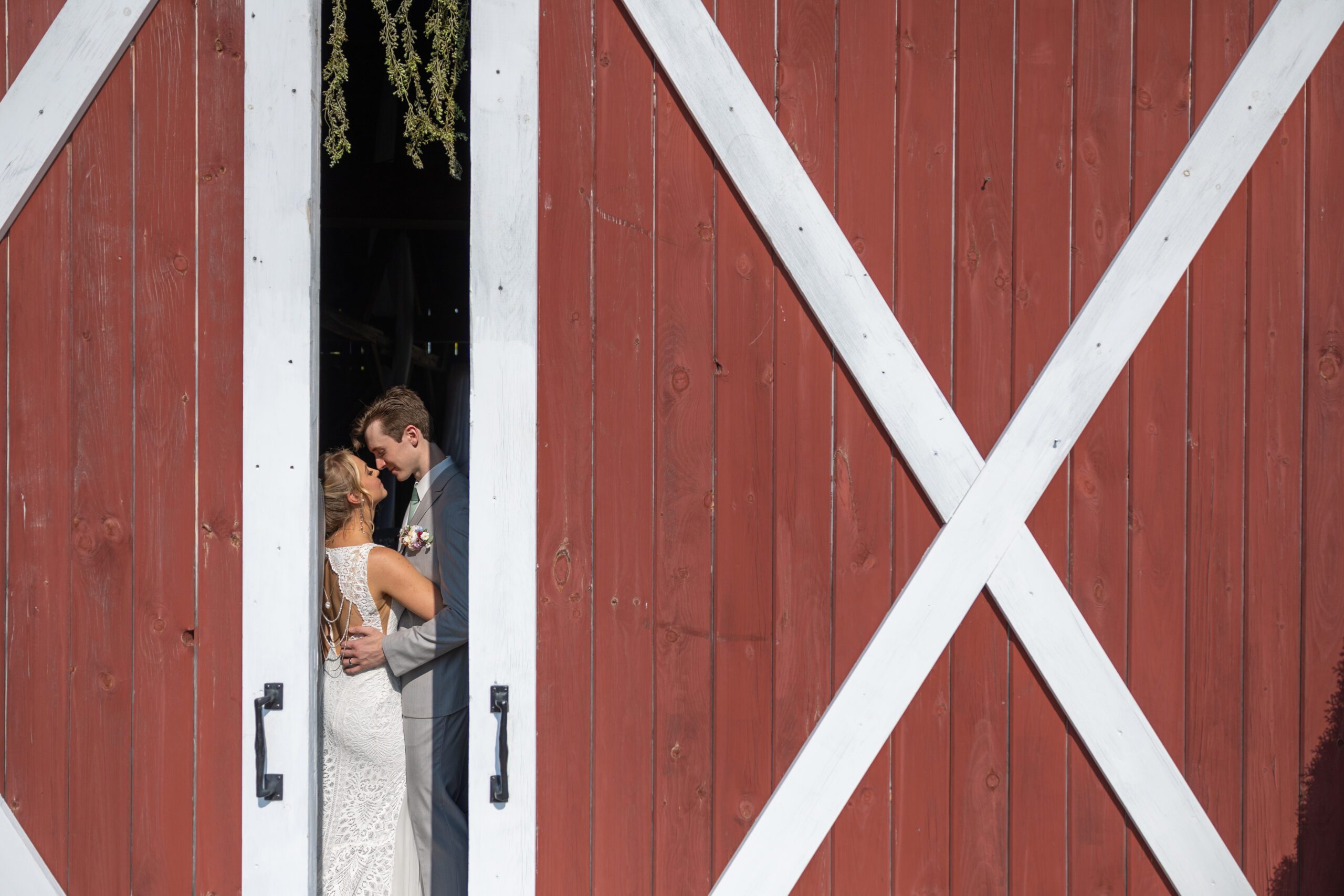 barn door open slightly portrait of wedding couple